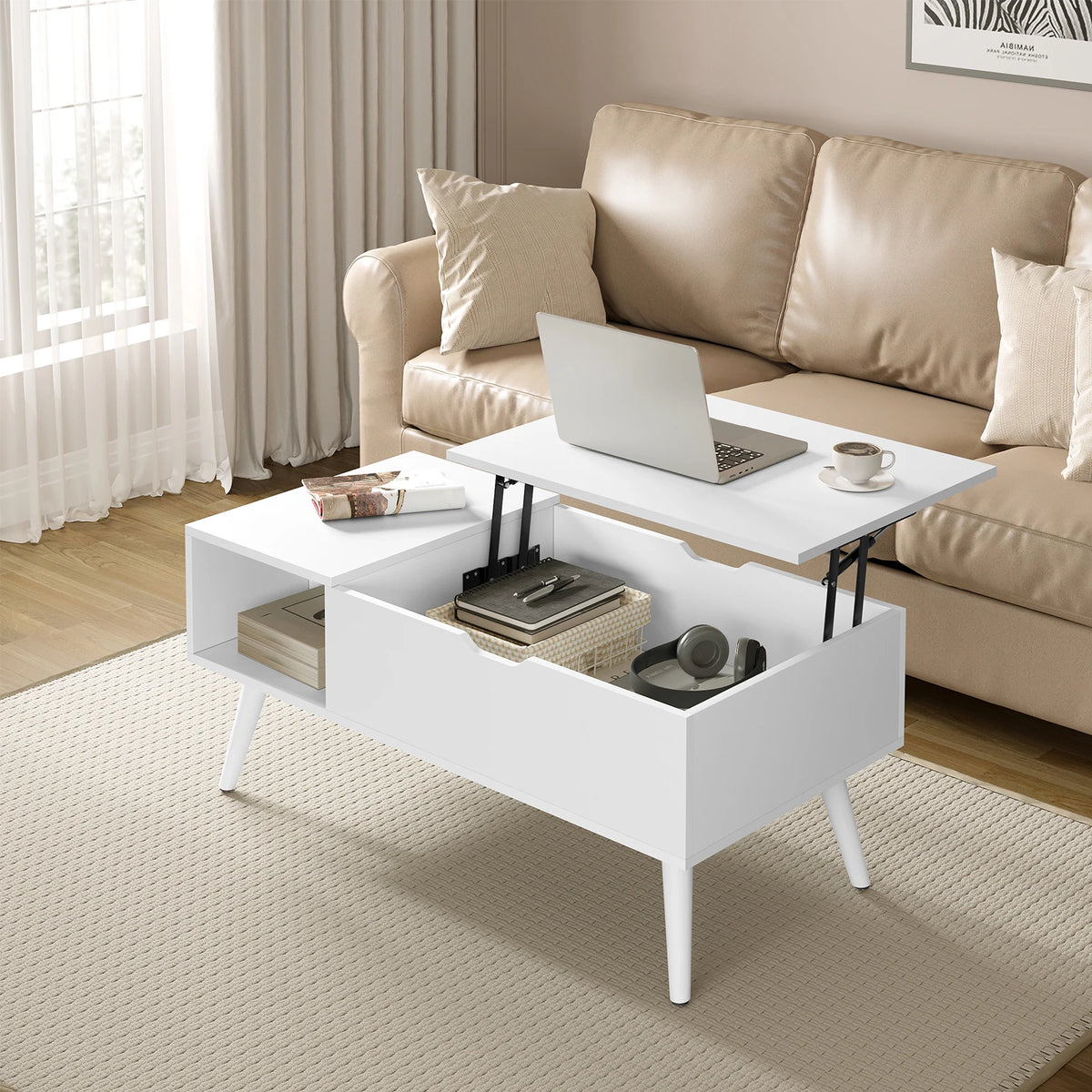 Table basse relevable blanche devant un canapé, plateau relevé avec ordinateur portable